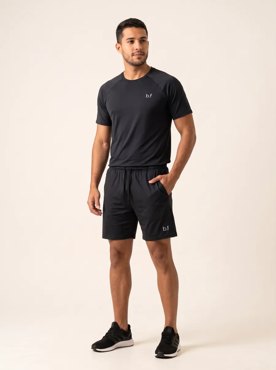Modelo de frente com o Conjunto Impulso preto: camiseta raglan e shorts com cordão
